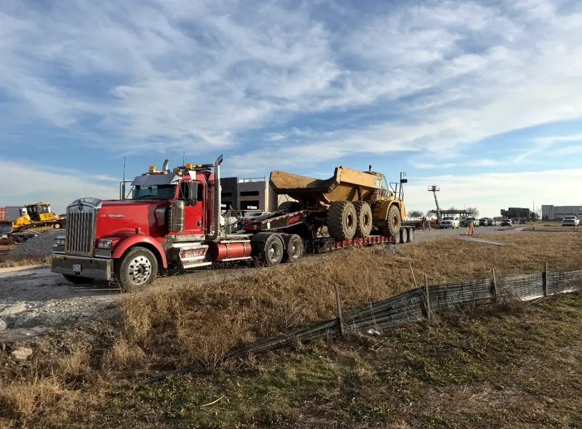 A man is standing in front of a tow truck that says tow truck
