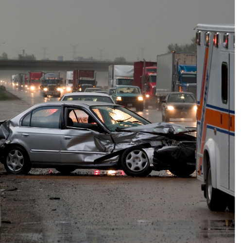 An ambulance is parked next to a damaged car