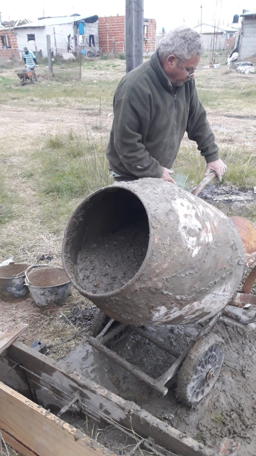 Un hombre está vertiendo hormigón en una hormigonera.