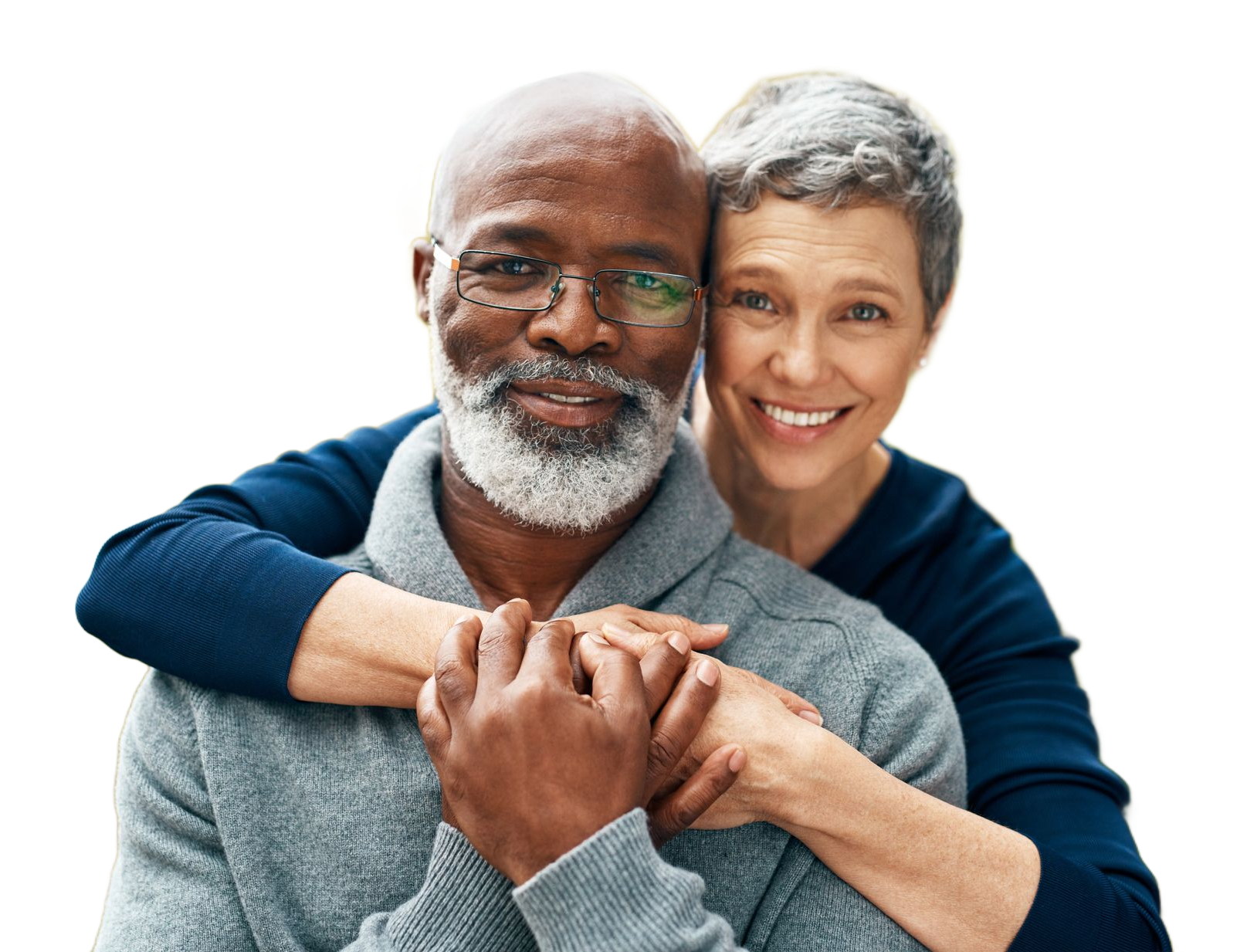 Smiling couple embracing outdoors. Woman leans head on man’s shoulder. They both laugh.