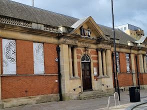 A large brick building with a clock on the front of it.