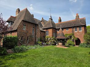 A large brick house with a lush green lawn in front of it.