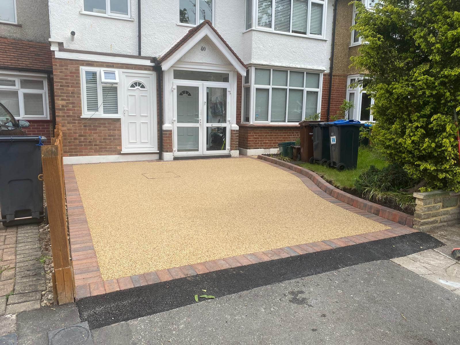 Golden resin driveway with a semi-detached house in the background.