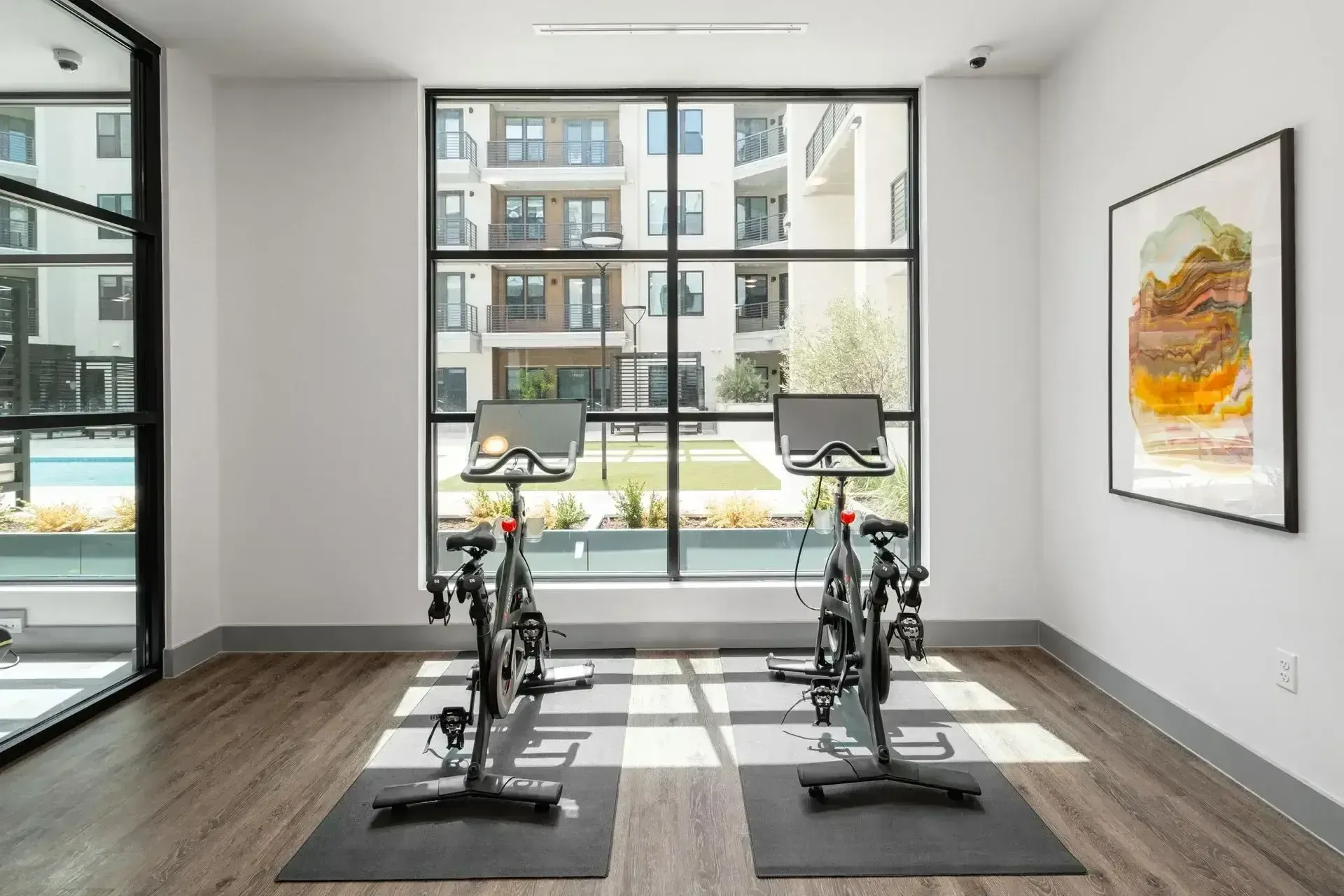 A gym with two exercise bikes and a large window at The Anderson 