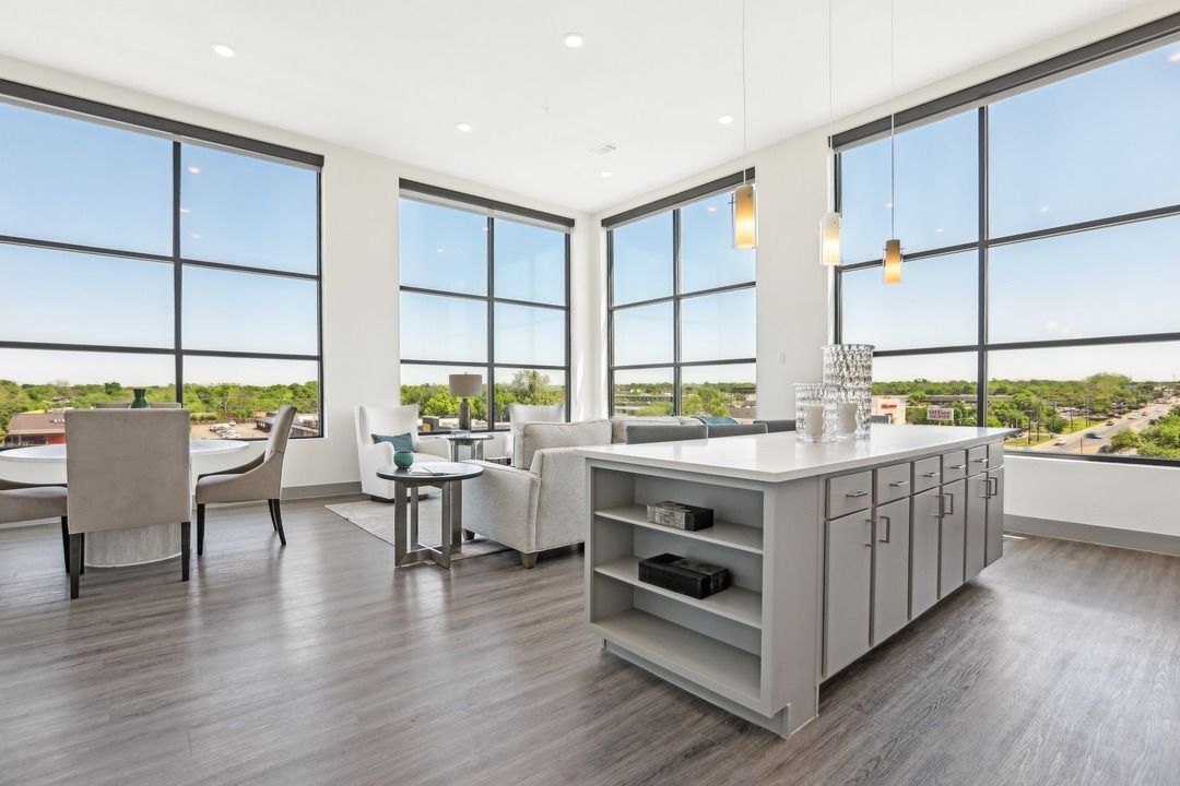 A living room with a large island in the middle and lots of windows.