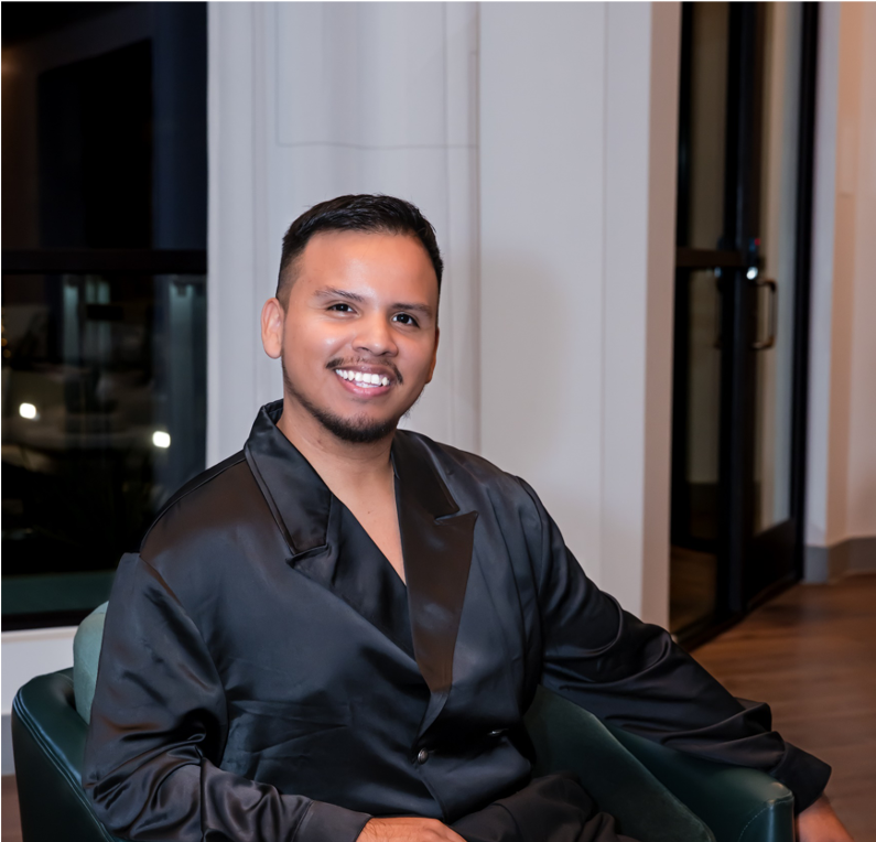 A man in a black shirt is sitting in a green chair.