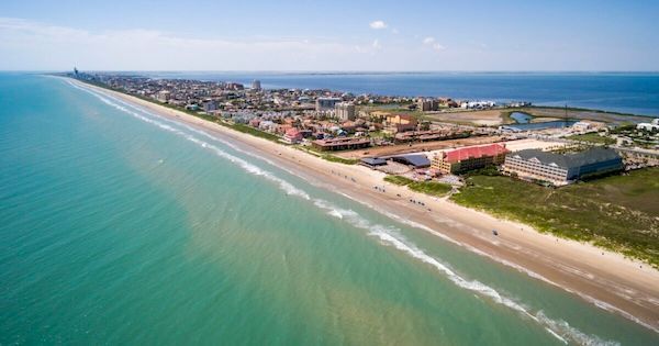 An aerial view of a long beach next to the ocean.