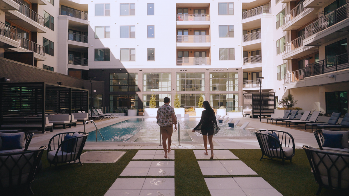 persons walking into the pool courtyard