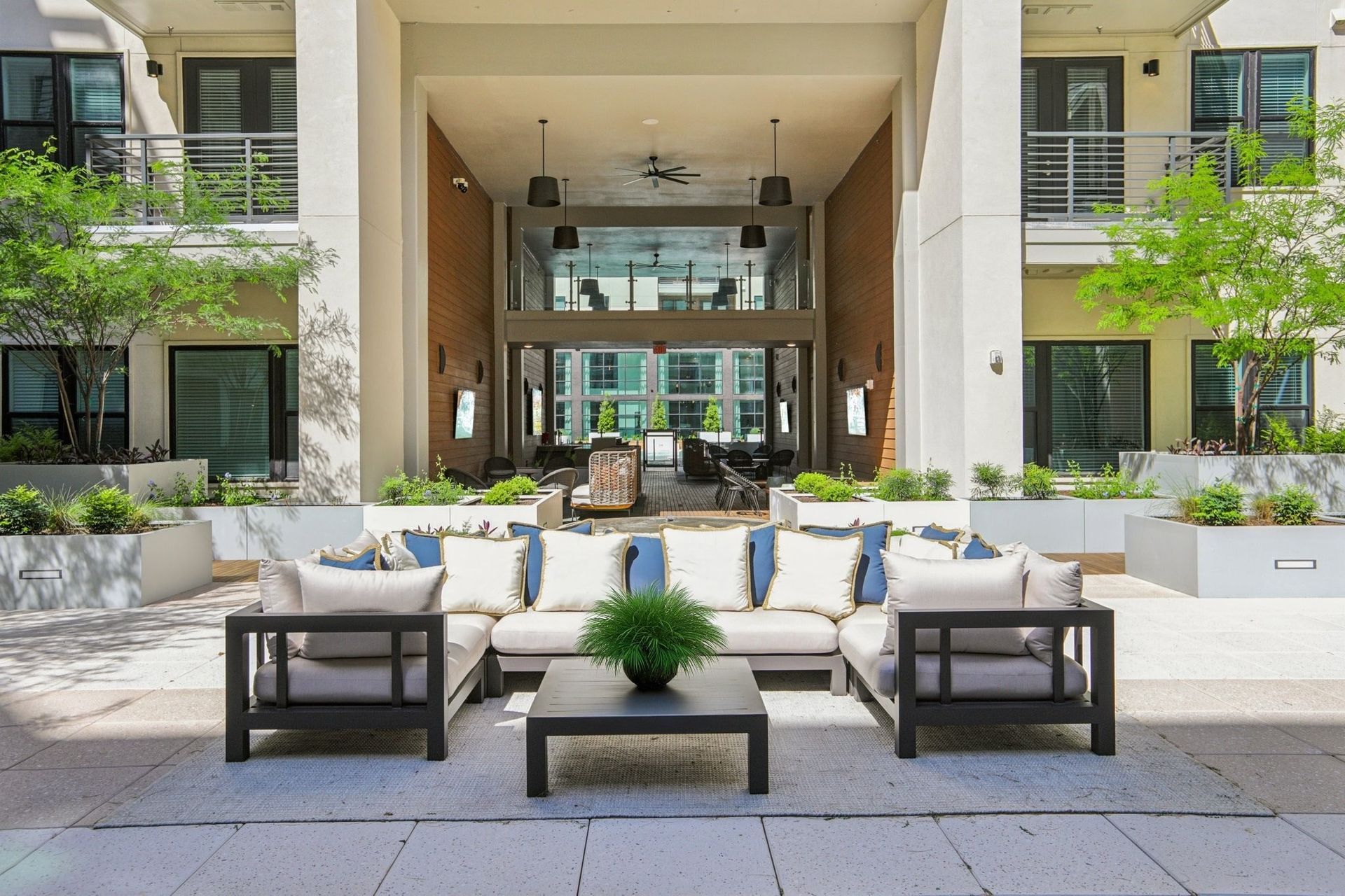 A patio area with a couch and chairs in front of a building.
