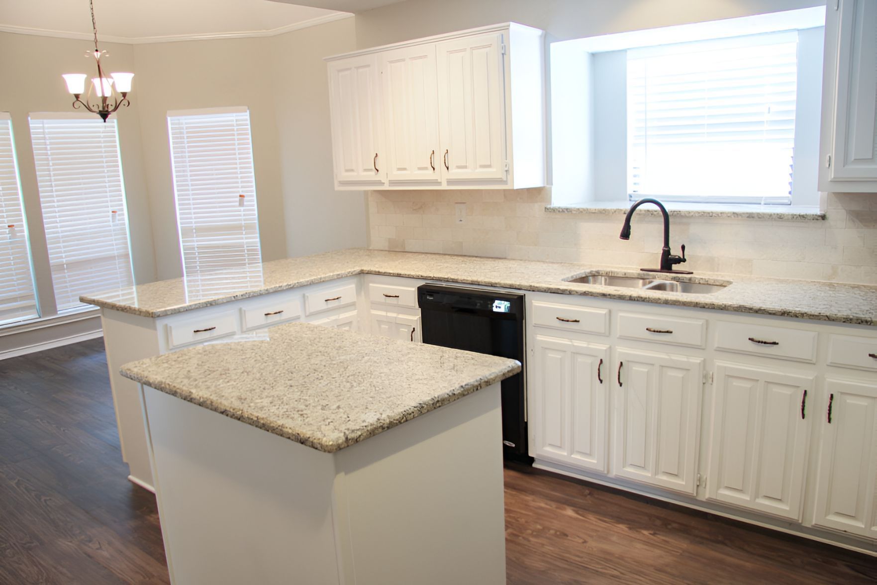 An Empty Kitchen With White Cabinets and Granite Counter Tops — Foreshore Kitchens In Yandina, QLD
