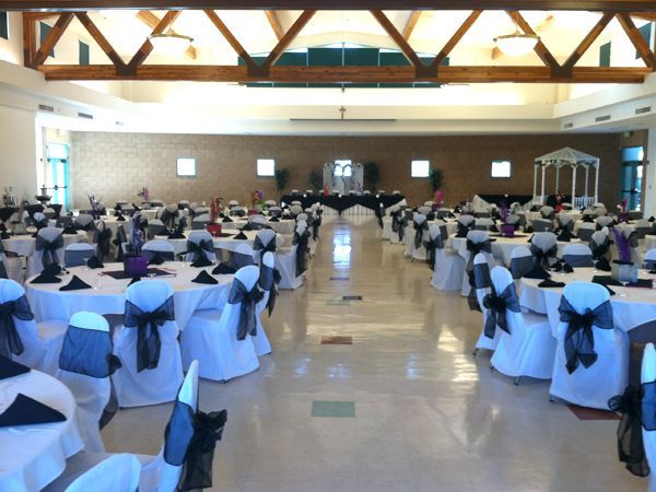 Banquet hall with round tables and white-and-blue chair covers set for an event