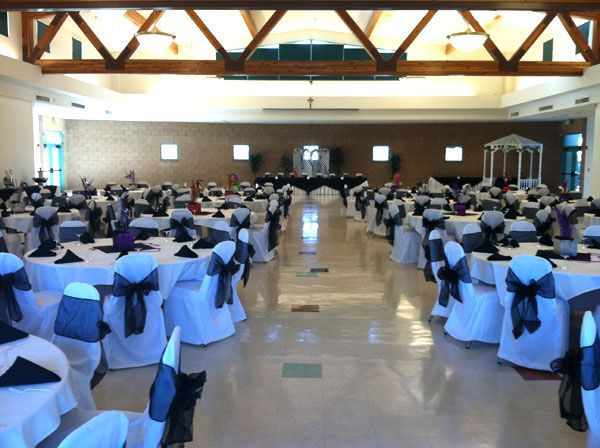 Banquet hall with rows of round tables dressed in white and blue, set for an event