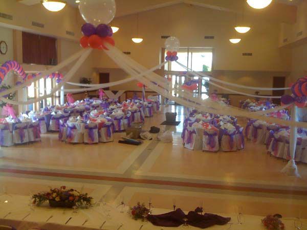 Decorated banquet hall with rows of gift bags and draped ribbons for a celebration