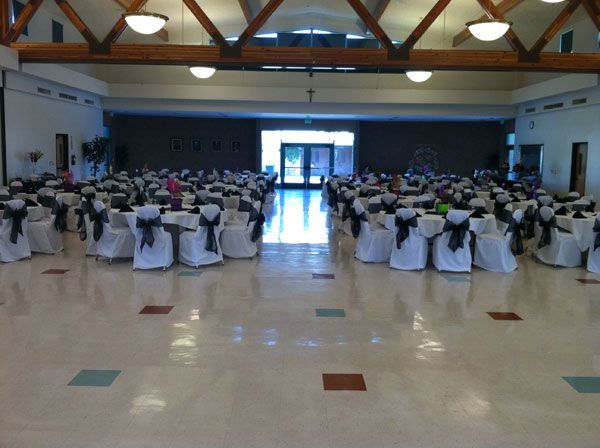 Banquet hall with rows of round tables and white chairs set for a formal event