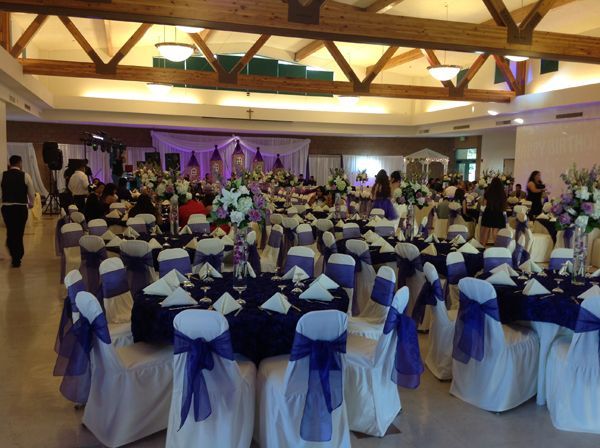 Banquet hall with round tables, blue-and-white chair covers, and guests seated for an event