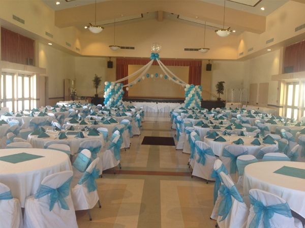 Banquet hall decorated with blue-and-white table settings and balloons for an event