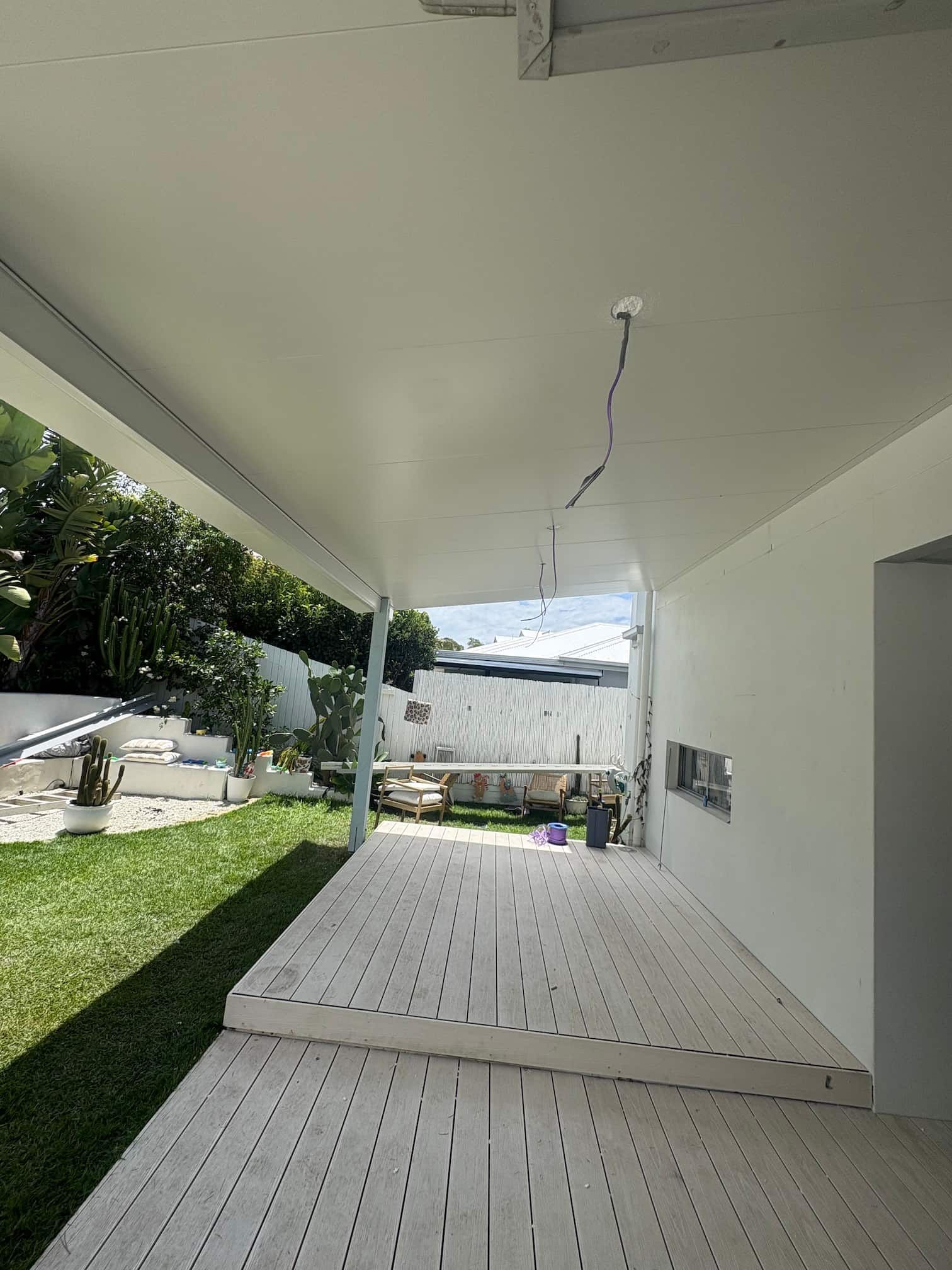 Modern bathroom with white walls, patterned floor tiles, and a wooden vanity.