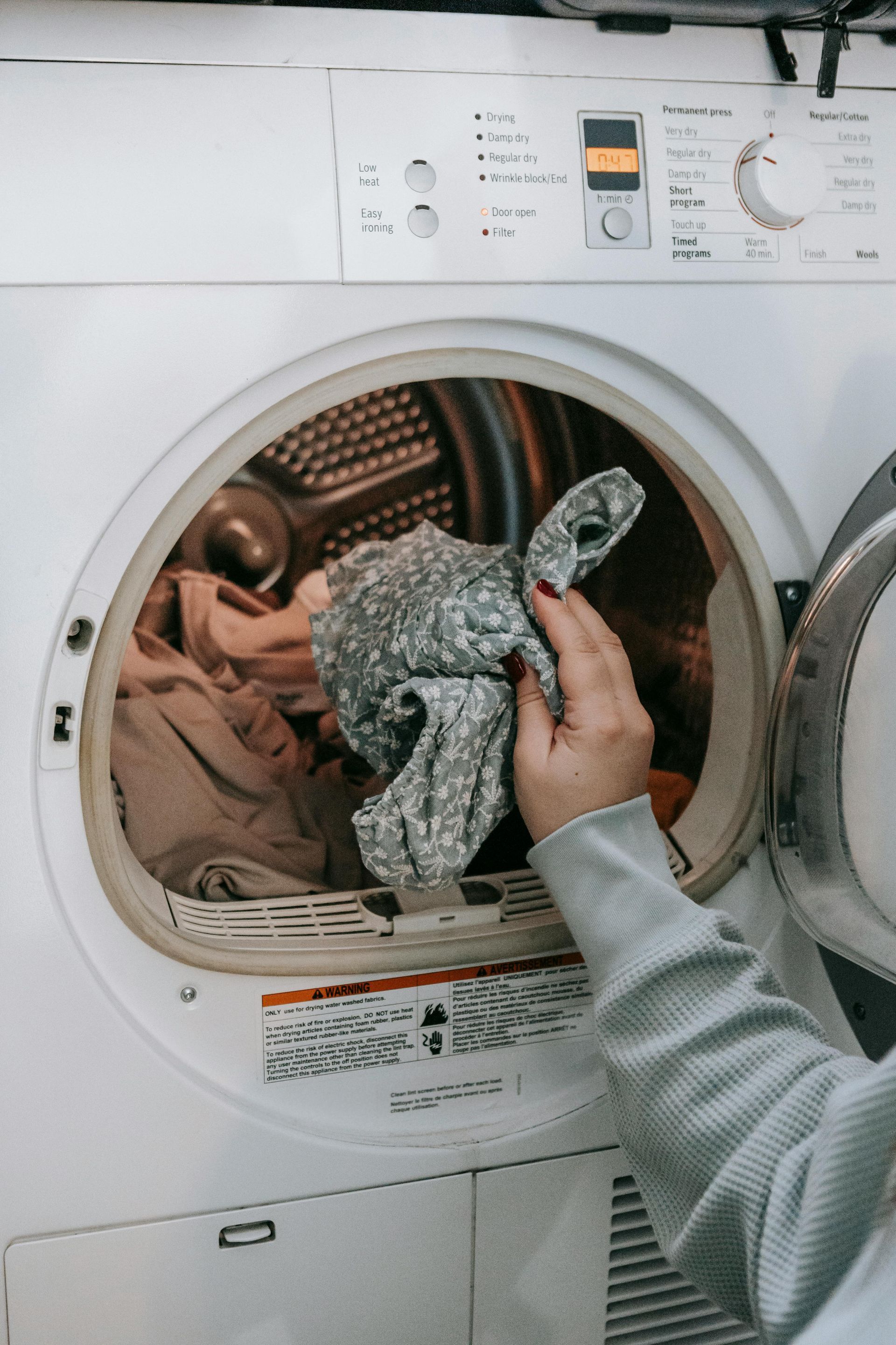 a person is putting clothes in a washing machine after their laundry was renovated