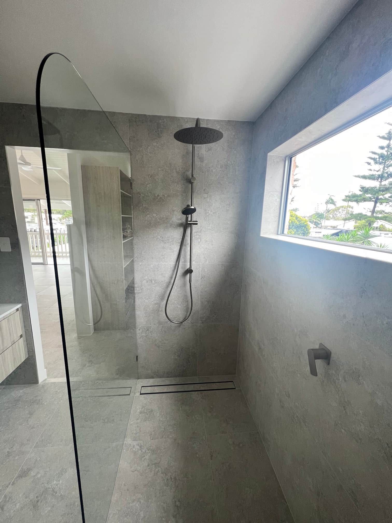 a bathroom with a walk in shower and a window