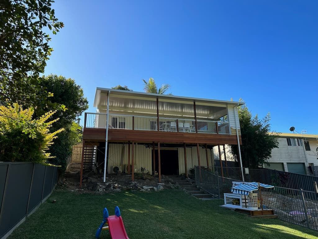 A house with a deck hanging over the backyard