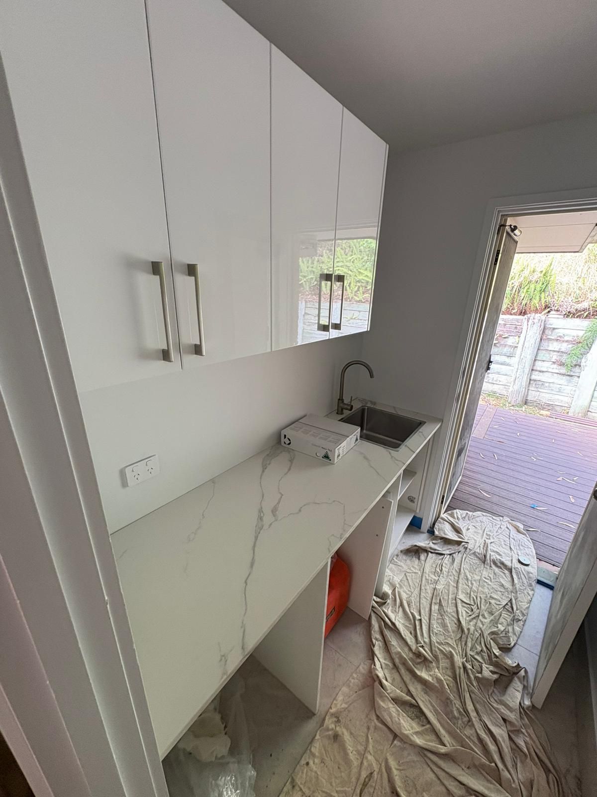 Modern bathroom with white walls, patterned floor tiles, and a wooden vanity.