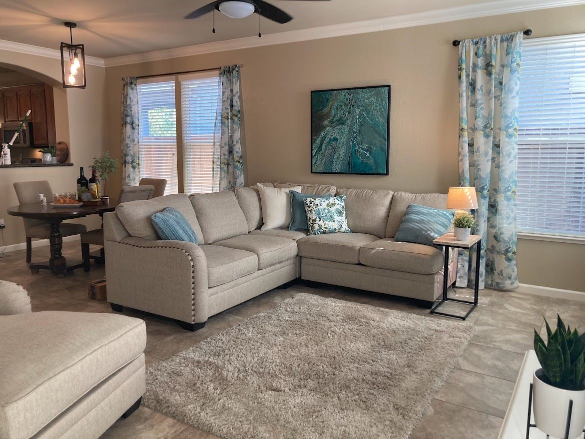 Living room with beige sectional sofa, area rug, and teal accents.