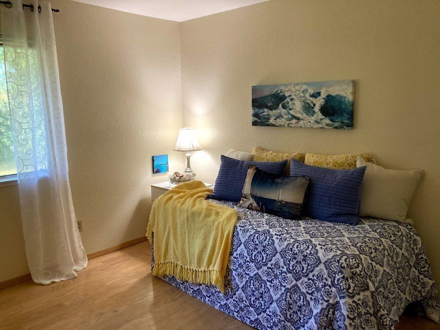 Bedroom with a daybed and ocean-themed decor in yellows and blues.