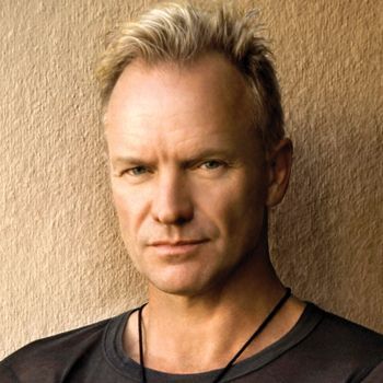 A head-and-shoulders portrait of Sting wearing a dark shirt and a black cord necklace against a textured beige background.