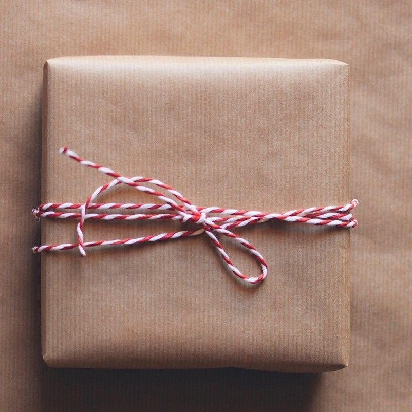 Brown wrapped gift with red and white twine bow.