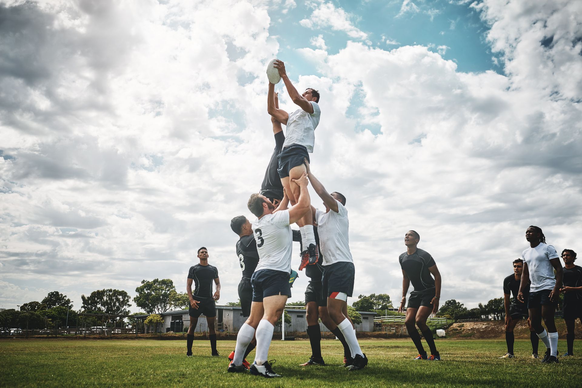 A team of men playing a rugby match outdoors in reading