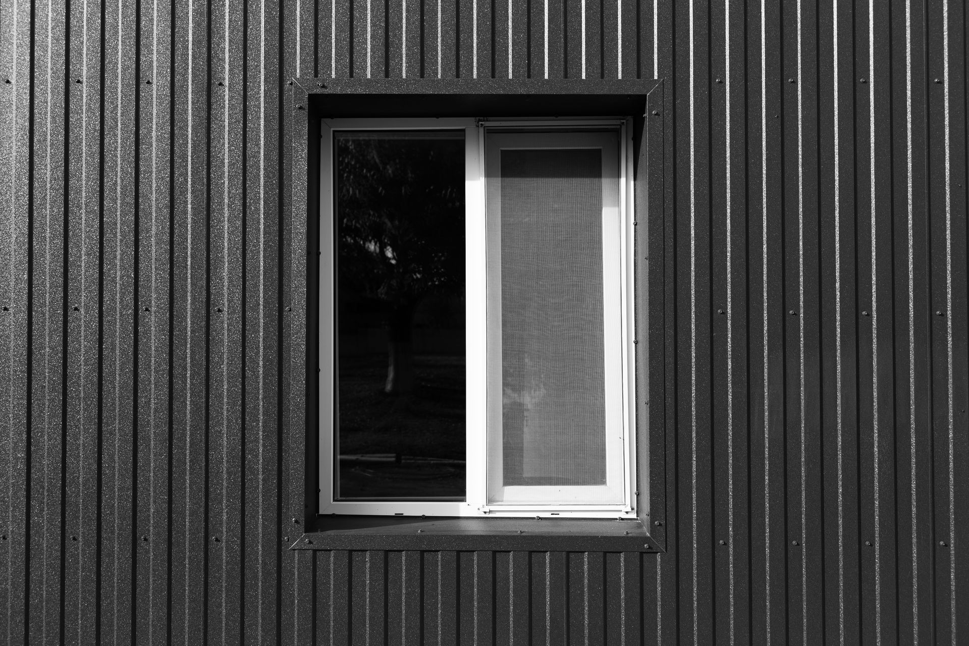 a black and white photo of a window on a black wall