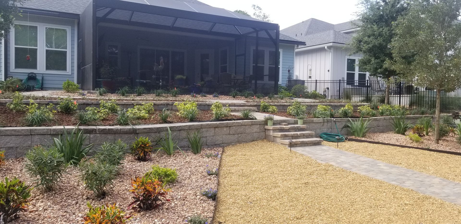 A house with a lot of plants in front of it.
