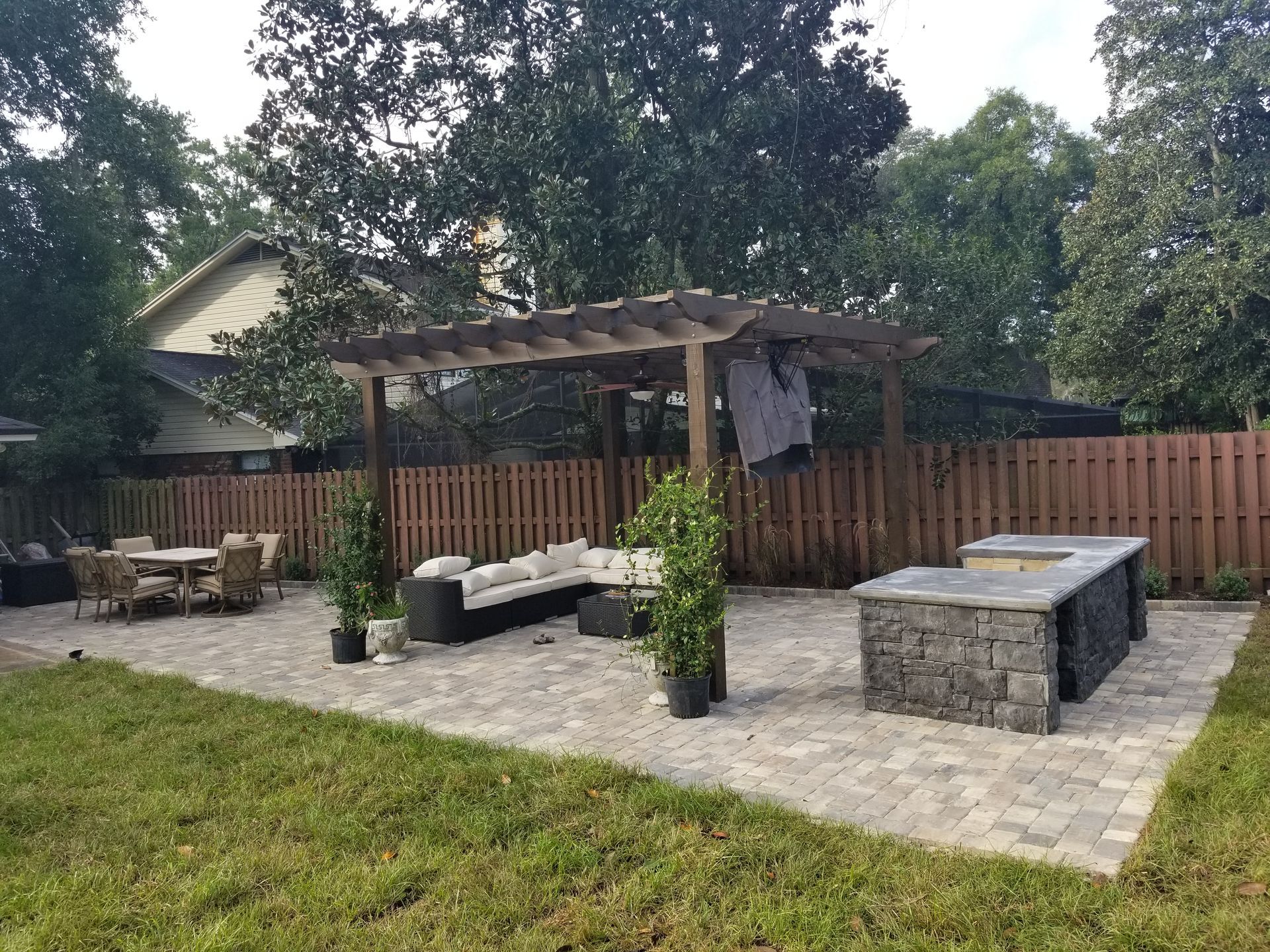 A backyard with a pergola and a fire pit.