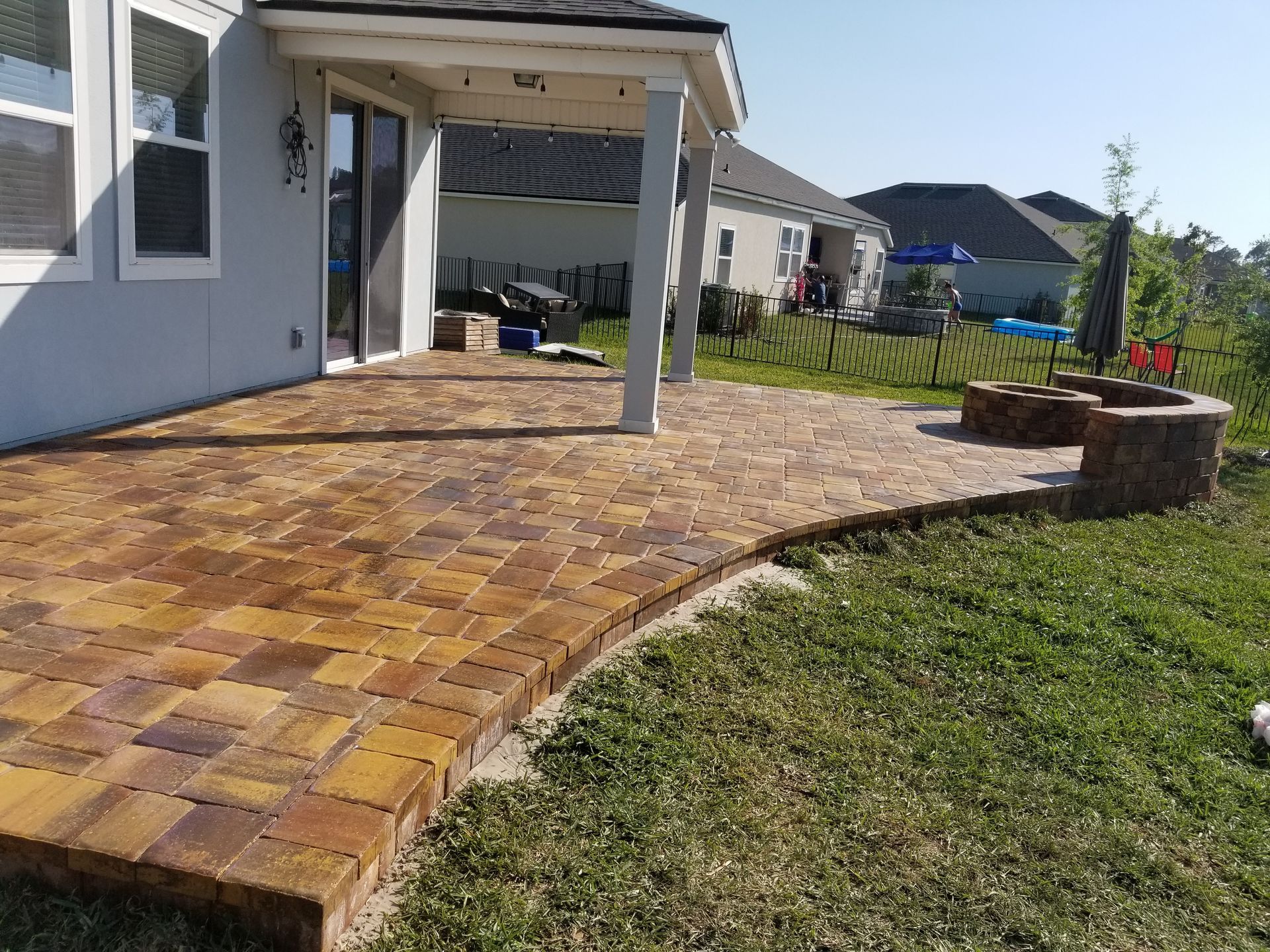 A patio with a fire pit in the backyard of a house.