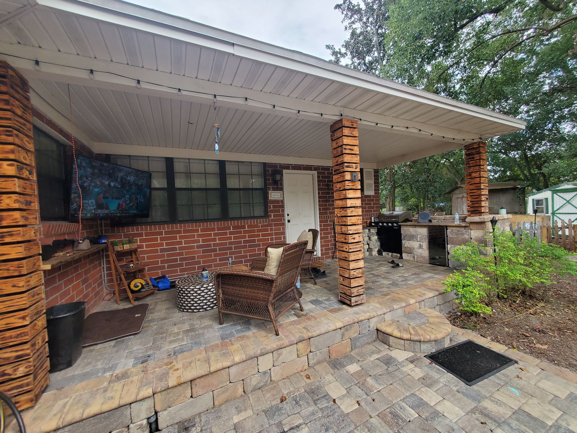 A brick house with a patio area and a covered porch.