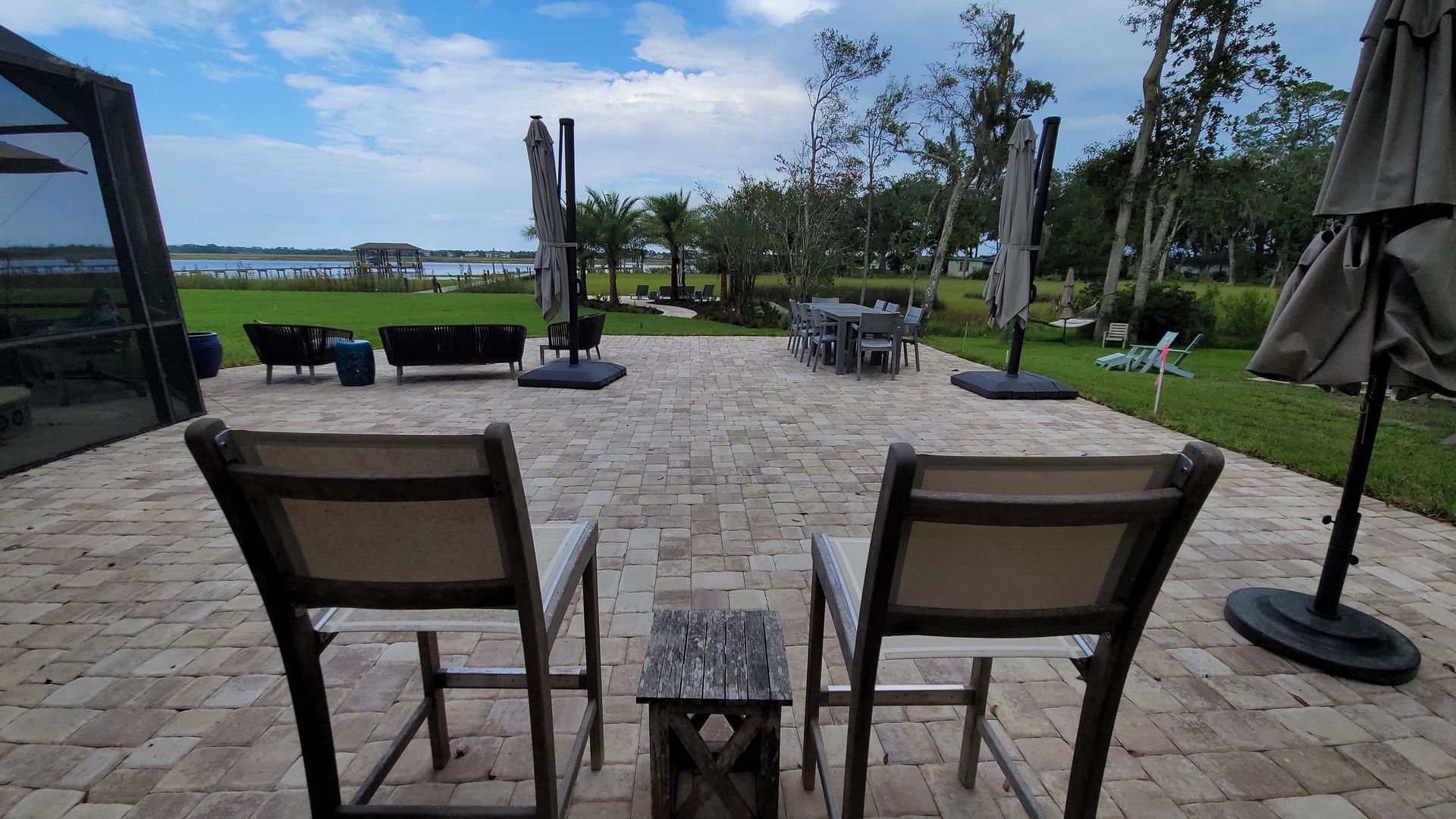 Two chairs are sitting on a patio with umbrellas.