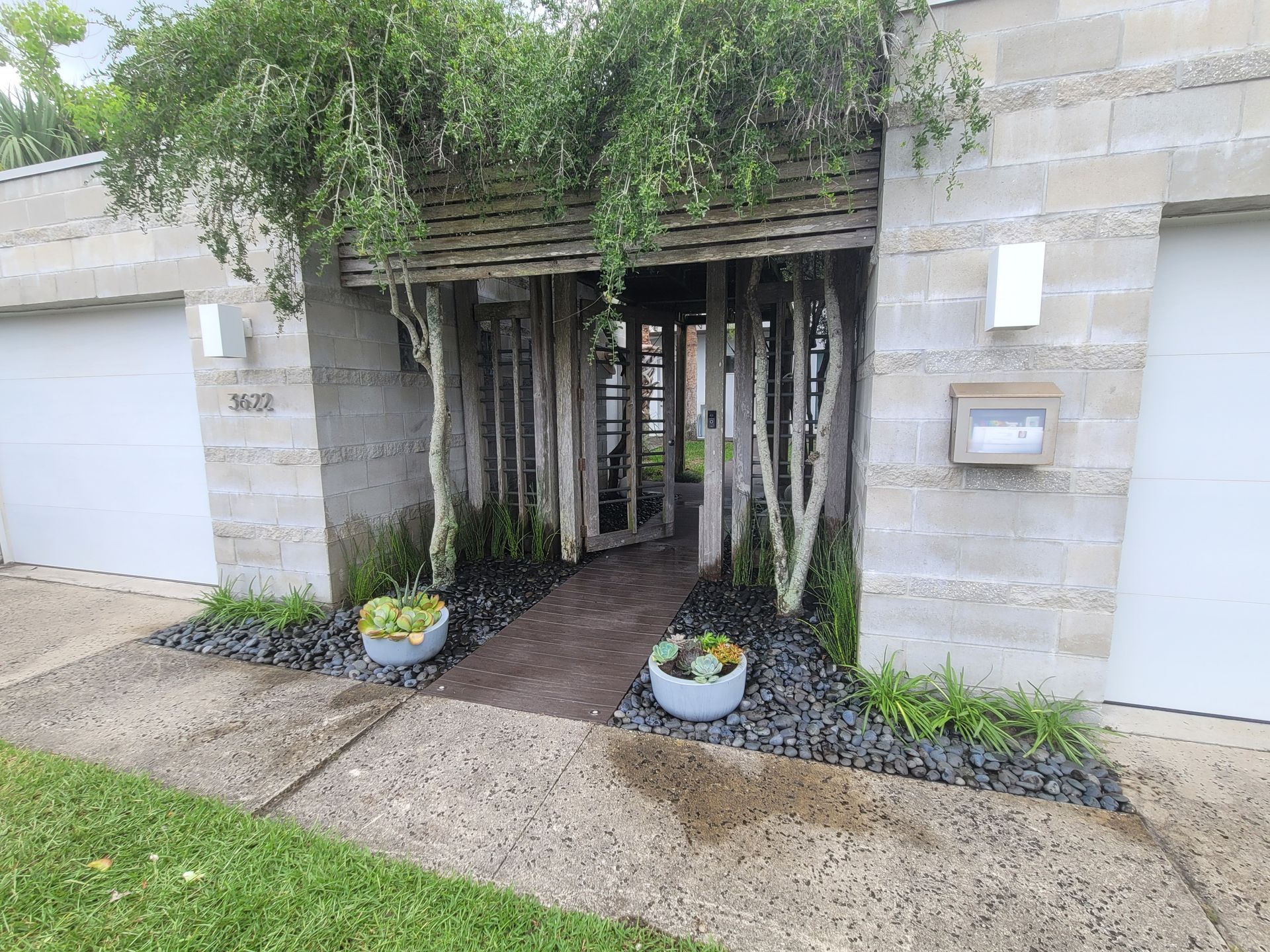 The entrance to a house with a fence and trees in front of it.