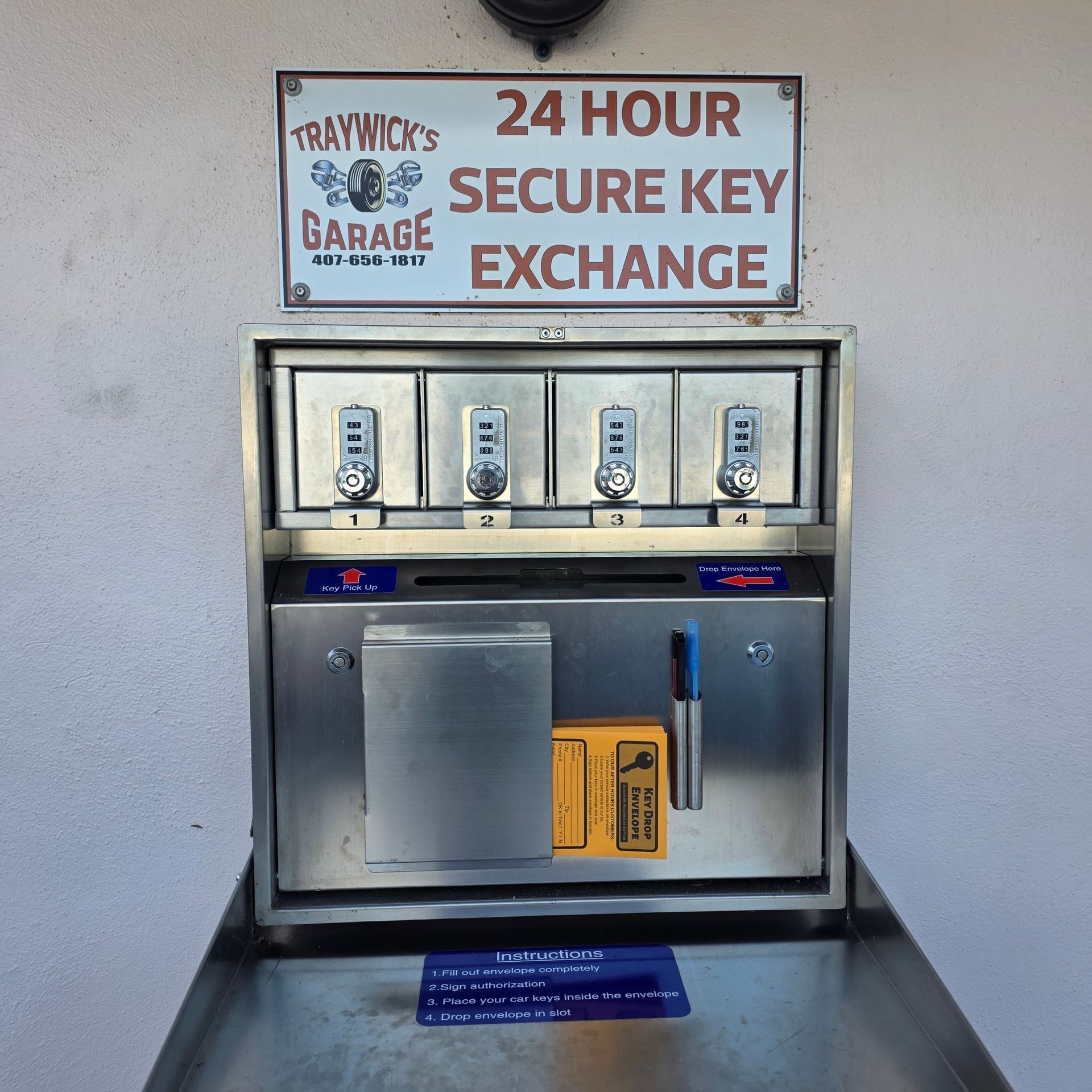 A 24-hour secure key exchange machine at Traywick's Garage. Stainless steel, four key boxes with combination locks.