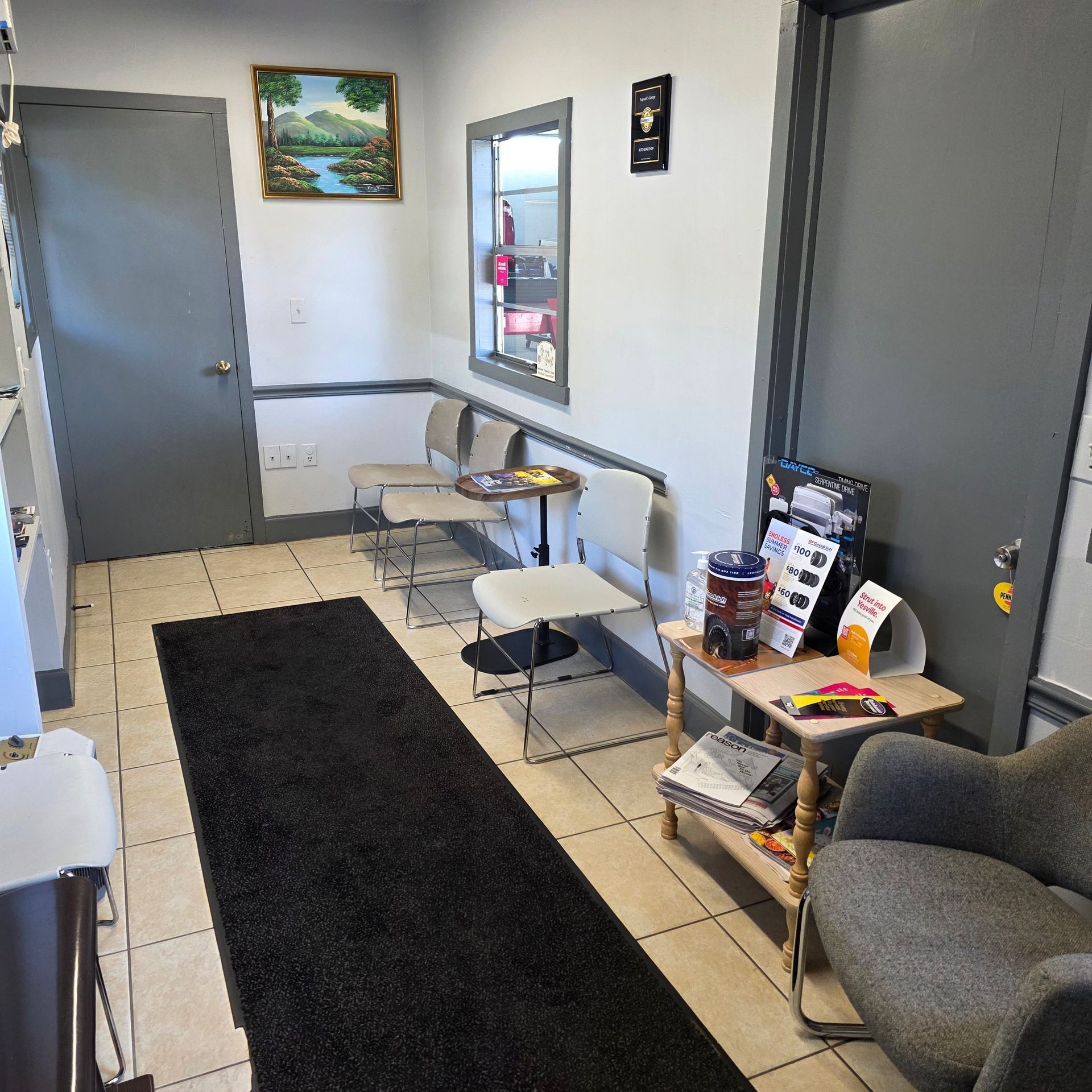 Waiting room with chairs, a rug, and a small table with reading materials.