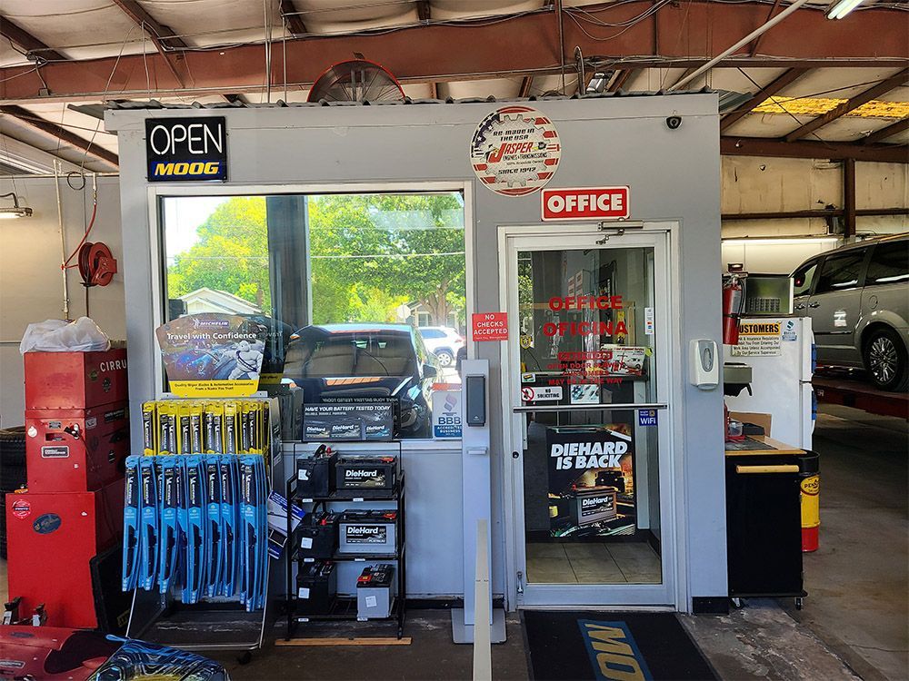 Auto repair shop exterior with open sign, a clear window and door to the office.