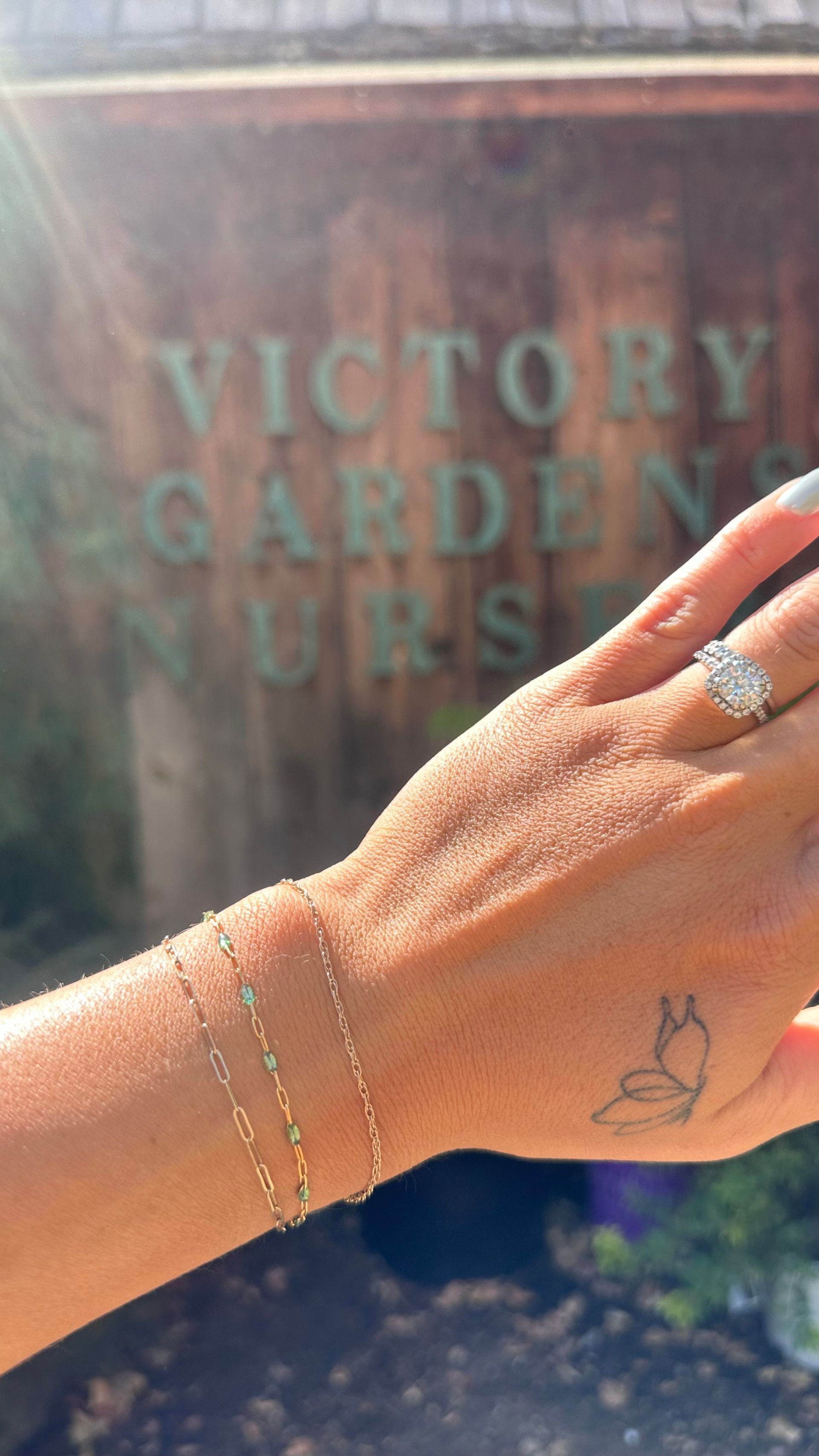 Hand with jewelry and butterfly tattoo in front of