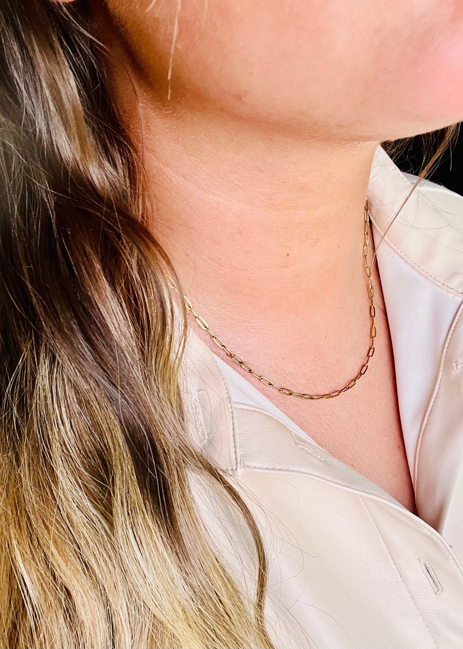 Woman wearing a delicate gold chain necklace. Soft lighting.