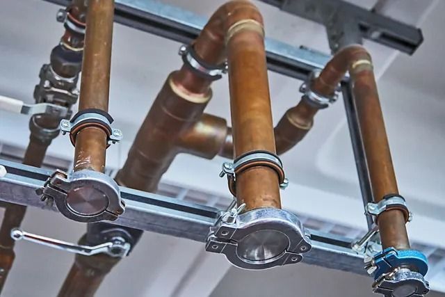 A bunch of copper pipes are hanging from the ceiling.