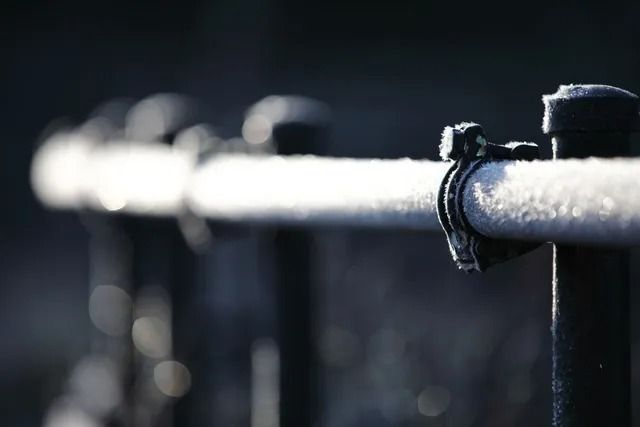 A close up of a railing with frost on it.