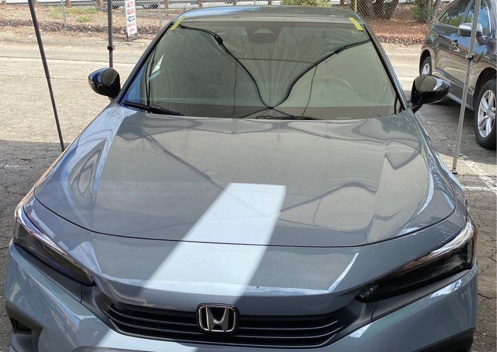 A gray honda civic is parked in a parking lot.