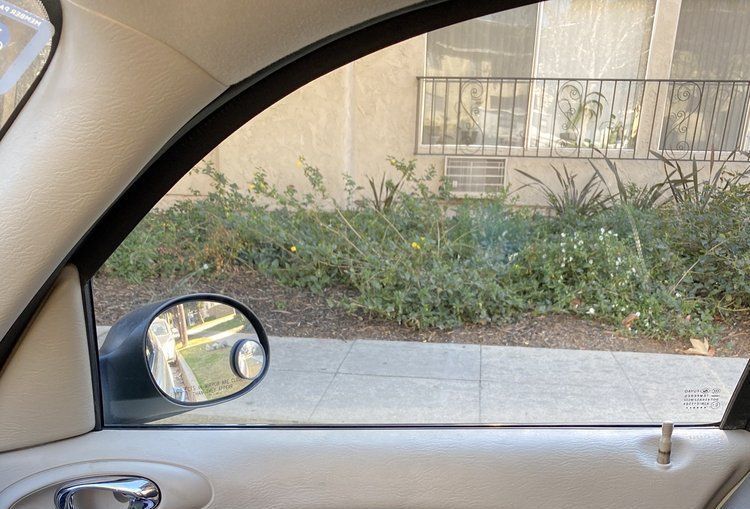 A car is parked on the side of the road and looking out the window.