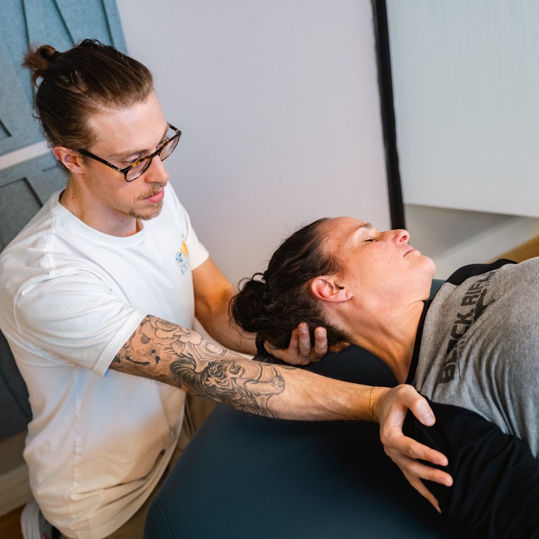 A man is stretching a woman 's neck on a table