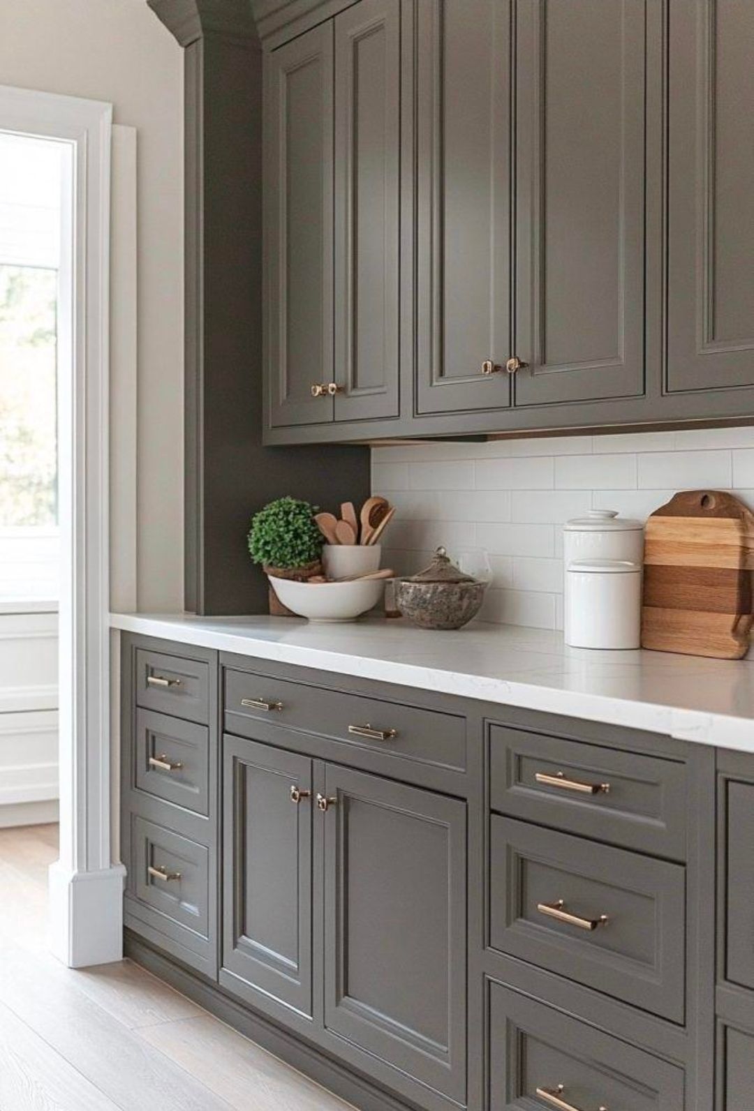 Modern kitchen with dark cabinets, green countertops, stainless appliances, and a window over the sink.