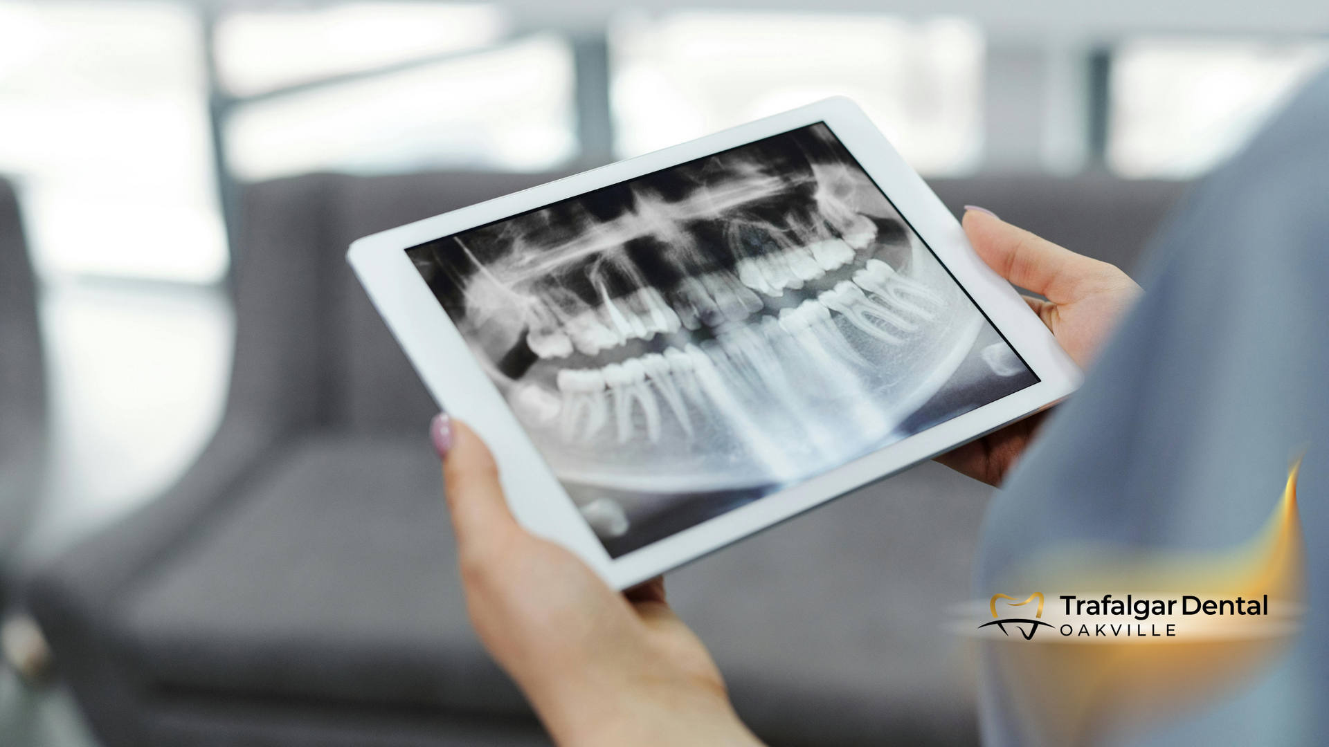 A person is holding a tablet with an x-ray of their teeth on it.