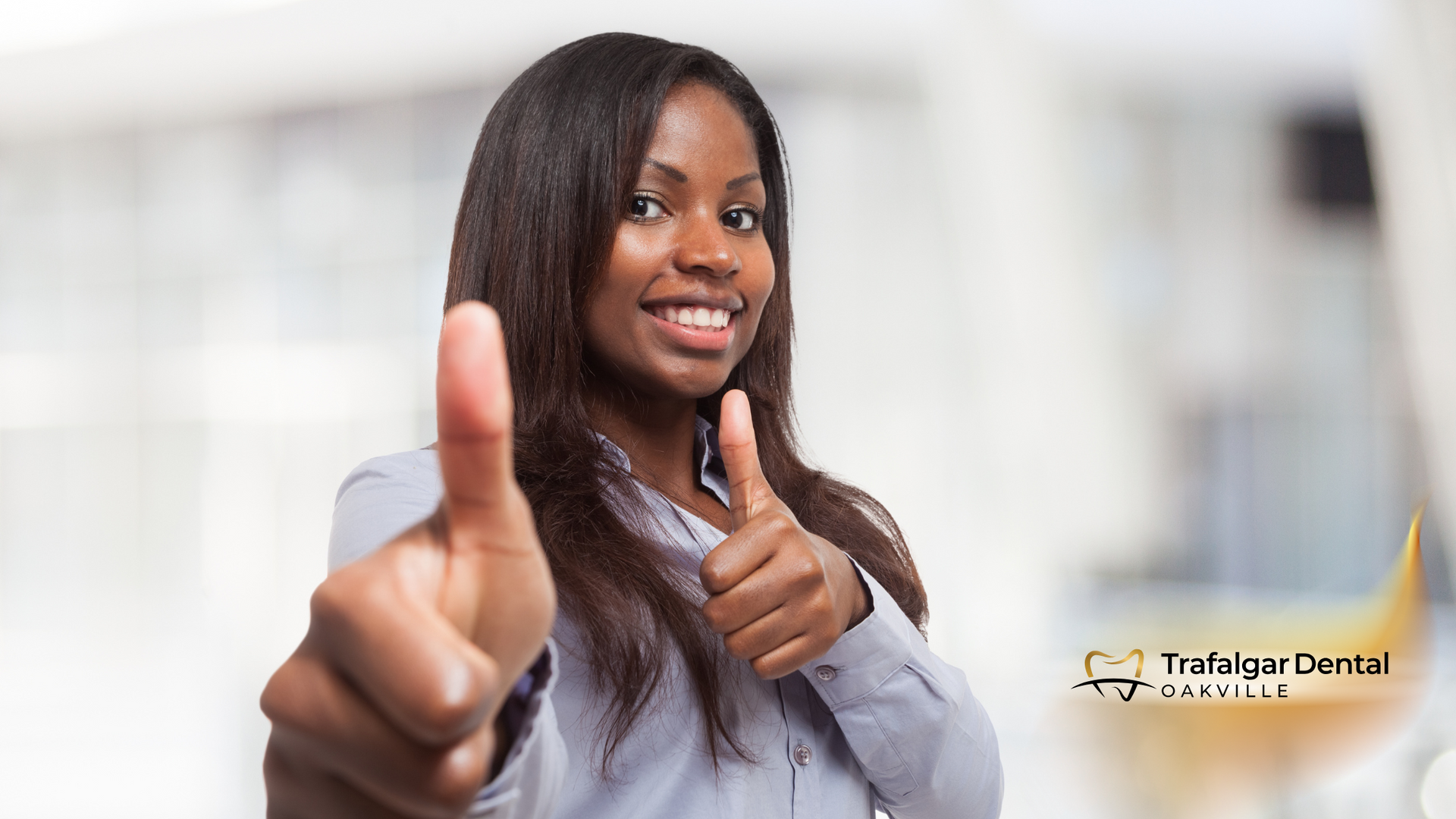 A woman is giving a thumbs up sign and smiling.